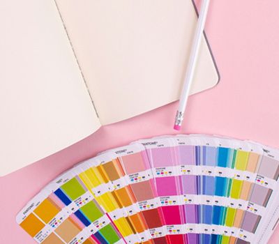 Cuaderno con paleta de colores en fondo rosa representando el Branding Visual