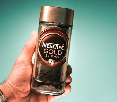 Persona sostiene un frasco de Nescafé en su mano