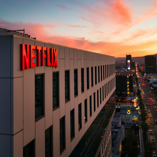 Logo de Netflix reflejado en la cima de un edificio en la ciudad