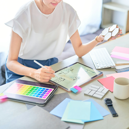 Mujer con diferentes elementos creativos realizando el branding visual de una marca