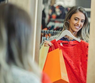 Mujer detallando prenda de ropa mostrando la relación de branding y la experiencia de cliente