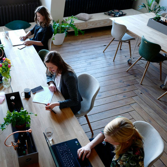 Grupo de trabajo de Unonu agencia sentado en mesa trabajando en estrategia de branding para startups