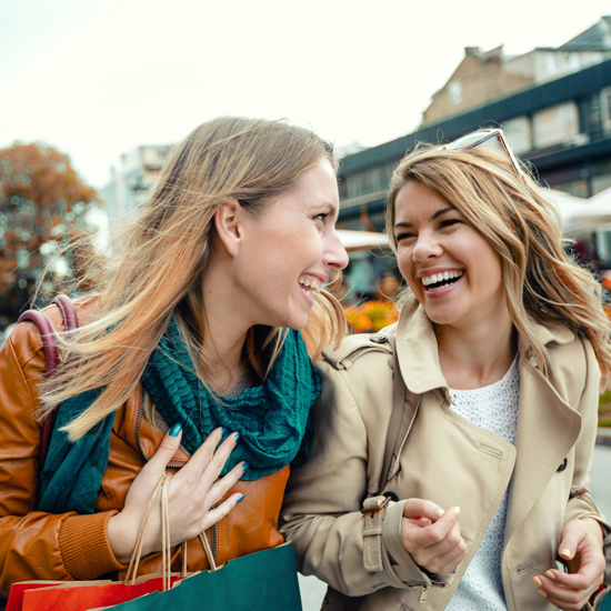 Dos mujeres felices de comprar mostrando la eficiencia de comunicación de marca y valor percibido con el branding