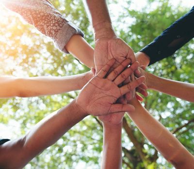Diferentes manos de personas unidas en el centro simbolizando estrategias de comunicación para marcas
