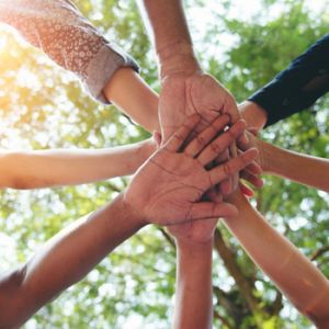 Diferentes manos de personas unidas en el centro simbolizando estrategias de comunicación para marcas