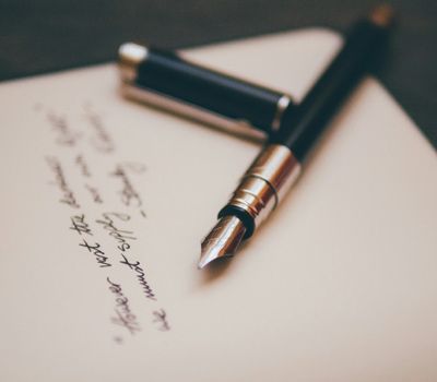 Pluma sobre papel escrito mostrando la transformación de firmas de abogados a través del branding y Unonu