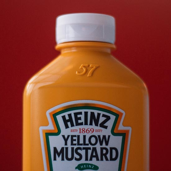 Plano cerrado de un empaque de mostaza marca Heinz como muestra del exito y los beneficios de invertir en un proyecto de branding