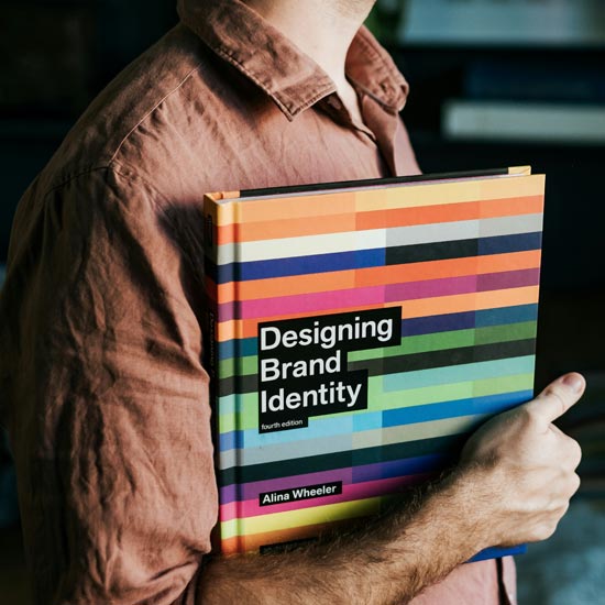 Plano cerrado de experto de Unonu con libro de branding e identidad gráfica efectiva para aplicar en una empresa de aseo