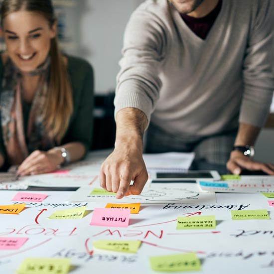 Equipo de profesionales de Unonu trabajando con cliente en un tablero mostrando innovaciones reciente en branding logístico eficiente para su marca